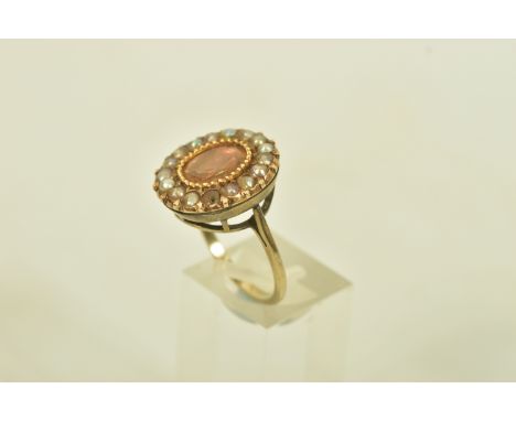 A FOIL BACKED TOPAZ AND SPLIT PEARL YELLOW GOLD CLUSTER RING, set with an oval shaped foil backed colourless topaz, within a 