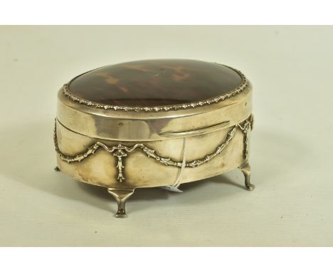 AN EARLY 20TH CENTURY SILVER AND TORTOISESHELL HINGED BOX, the oval trinket box with embossed garland and swag detail to the 
