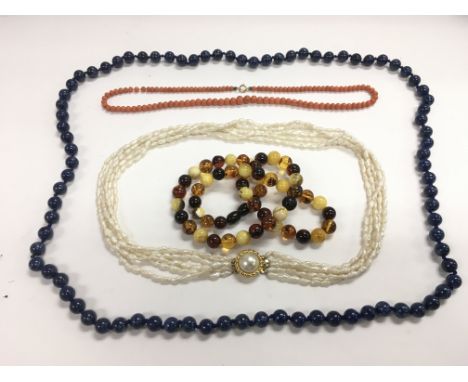 Four necklaces comprising Lapis Lazuli, coral, amber and pearl.