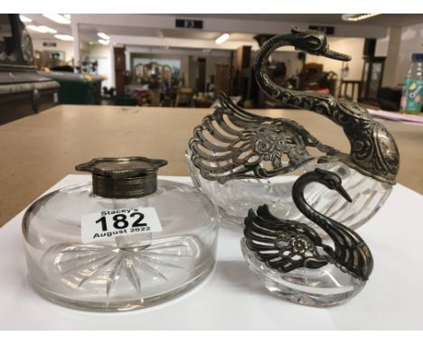 A glass inkwell with a silver lid, together with two posy vases in the form of swans