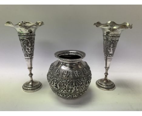 3 pieces of Burmese silver to include 2 fluted rim vases and a small globe shaped jar with deep relief designs.