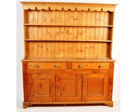 A 19th century Victorian pine kitchen dresser having as stepped cornice over a two tier plate rack over twin drawers and a do