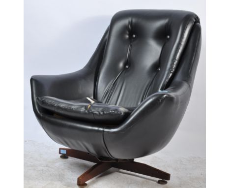 A vintage circa 1970s 20th century Danish inspired black leather egg chair having a button back cushioned seat raised on a fo