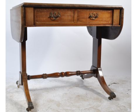 An early 19th century George III mahogany sofa table having drop leaves over a single drawer with brass handles raised on spl