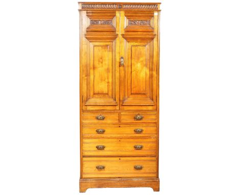 A 19th Century Art &amp; Crafts solid oak wardrobe chest compactum having a carved cornice top with double door wardrobe sect