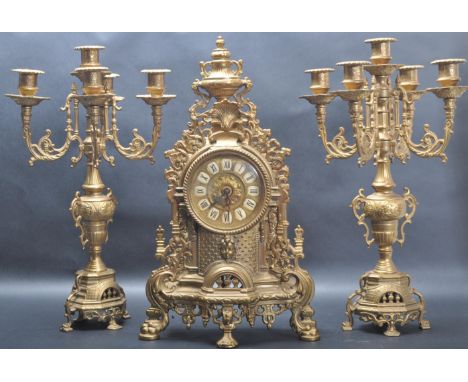 A 19th century French Empire style garniture mantel clock having pierced floral decoration to the sides, white enamel clockfa