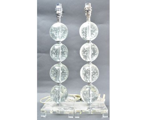 A pair of retro vintage style lamps having repeating bubble control spheres to the column raised on a square base. Measures 4