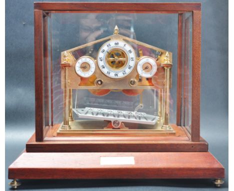 A late 20th century Congreve rolling ball platform clock having three dials with skeleton movement raised on a wooden base. C