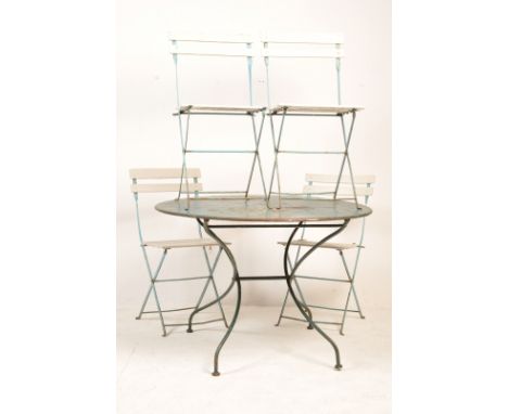 A vintage retro mid 20th century circa 1960’s French cafe bistro folding table and chairs. The metal table having a circular 