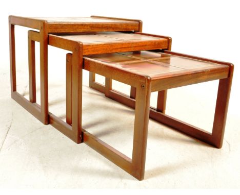 A retro vintage mid 20th century circa 1960s teak wood nest of tables having West German style tiles to the top raised on qua