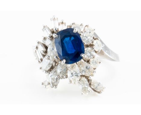 A SAPPHIRE AND DIAMOND RINGClaw set with an oval cut sapphire and round brilliant, marquise and baguette diamonds, in a twist