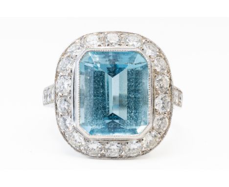 AN AQUAMARINE AND DIAMOND CLUSTER RING, BOXEDWith a central bezel set emerald cut aquamarine measuring 11.74mm x 10.25mm x 6.