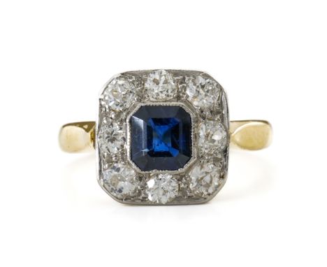 A SAPPHIRE AND DIAMOND CLUSTER RINGWith central square emerald cut sapphire, surrounded by eight old cut diamonds, all bezel 