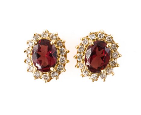 A PAIR OF GARNET AND DIAMOND CLUSTER EARRINGS, BOXEDWith central oval cut garnets measuring 8.09mm x 6.15mm, with a surround 