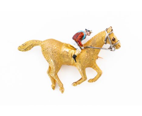 A HORSE AND JOCKEY BROOCHWith an enamel jockey wearing a red shirt with blue sash, on a horse with textured body and red ston