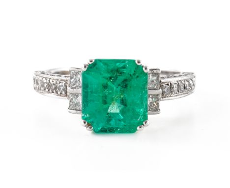 AN EMERALD AND DIAMOND RINGClaw set with a central emerald cut emerald measuring 8.86mm x 7.93mm with an stated weight of 2.6