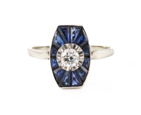 A SAPPHIRE AND DIAMOND RING, BOXEDWith central transitional cut diamond, surrounded by calibre cut sapphires, mounted in whit