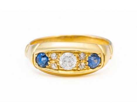 A SAPPHIRE AND DIAMOND RINGWith a central round brilliant diamond and two round cut sapphires, mounted in 18ct yellow gold, h