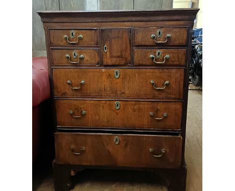 A 19th century mahogany chest, having a central cupboard door, flanked by four short drawers, above three long drawers, on a 