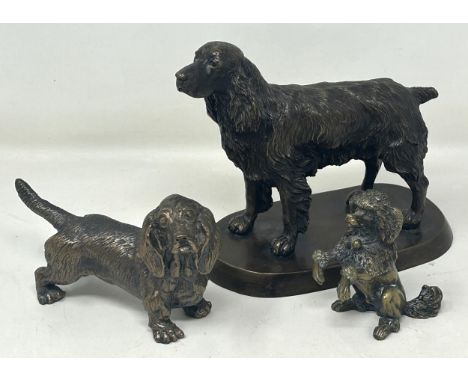 A bronze figure of a cocker spaniel, on a rounded rectangular base, 14 cm high, a bronze figure of a dachshund and a bronze f