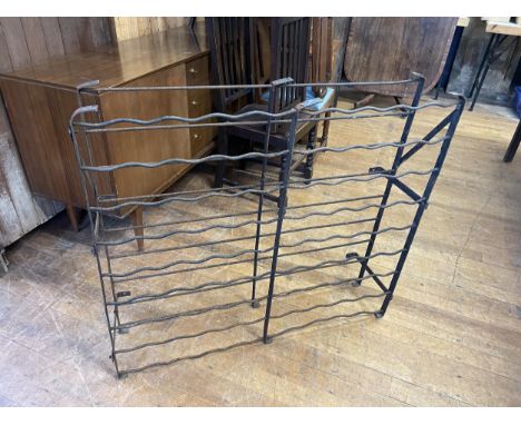 A wrought iron wine rack, 103 cm wide, and a trunk