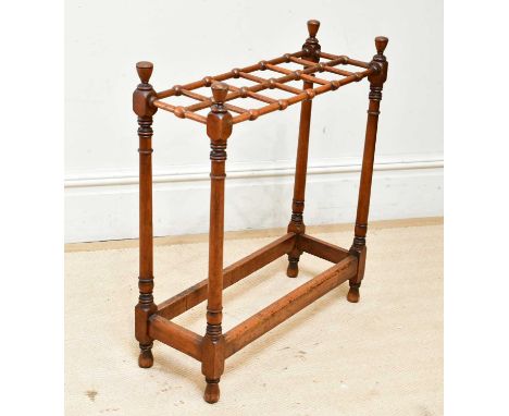 An early 20th century Arts and Crafts style twelve division stick stand, width 62cm.