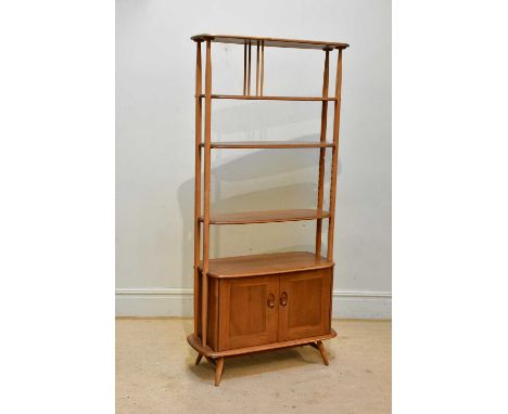 ERCOL; a vintage elm room divider, with an arrangement of three fixed shelves above two panelled cupboard doors, width 84cm, 
