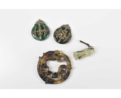 Two green hardstone pendants, both with white metal mounts, a green hardstone netsuke and a bi disc (4). 