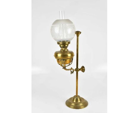 A Victorian brass adjustable oil lamp with bulbous frosted glass shade, the brass reservoir supported by three arms mounted w