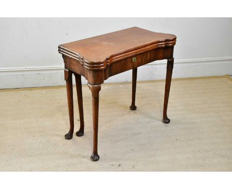 A George III mahogany triple top foldover games table, the hinged cover enclosing backgammon and chess board, the second cove