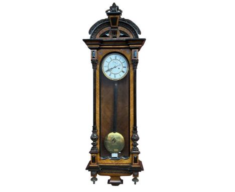 A late 19th century walnut cased Vienna style wall clock, with white enamel dial set with Roman numerals, length 122cm.