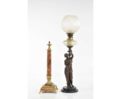 An early 20th century bronzed figural oil lamp, representing a classical maiden supporting a frosted glass reservoir and shad