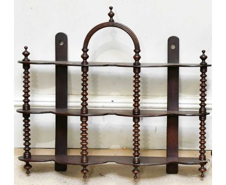 A 19th century mahogany three-tier wall shelf, with bobbin turned columns and central arch with finial, height 62cm, width 67