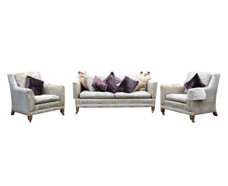 DURESTA; a Trafalgar type drop end two-seater sofa terminating on brass castors, with two matching elbow chairs upholstered w