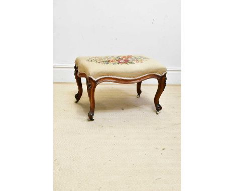 A Victorian carved walnut serpentine stool, with tapestry top and carved cabriole supports.Condition Report: Age related wear