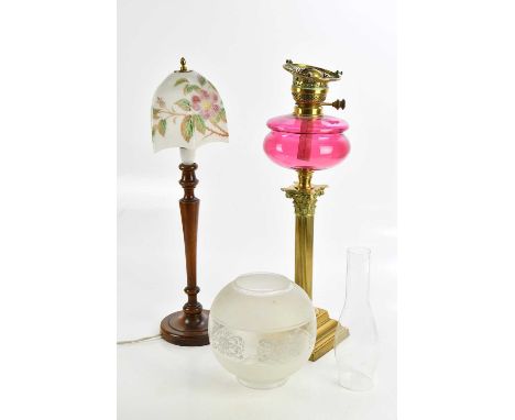 A 19th century brass and cranberry glass oil lamp, height 55cm, with a mahogany lamp with glass shade, height 59cm.Condition 