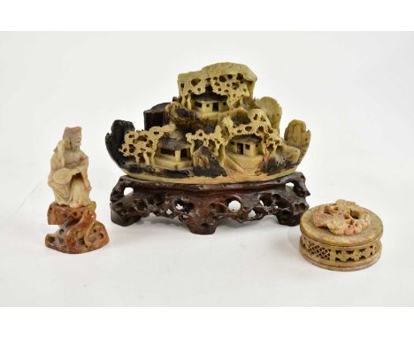A Chinese carved soapstone model of figures and houses in landscape effect detail, a hardstone figure and an Indian hardstone