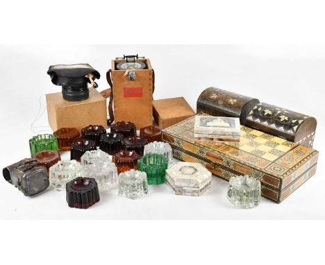 A collection of eighteen glass furniture stands, with a bicycle lamp, a gas mask and a Saura Hand Bearing Compass, type HB-65