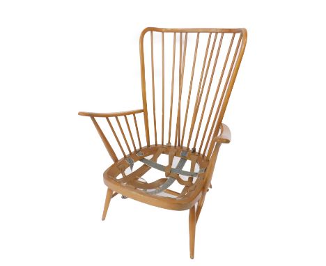 An Ercol beech spindle back fireside armchair, in need of upholstery, raised on turned legs united by an H framed stretcher.
