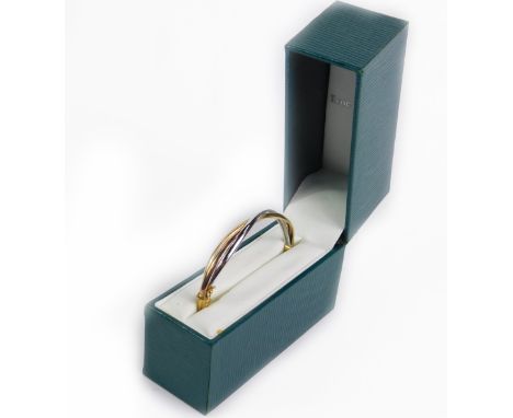 A three colour gold bangle, on a snap clasp, 5.9g.