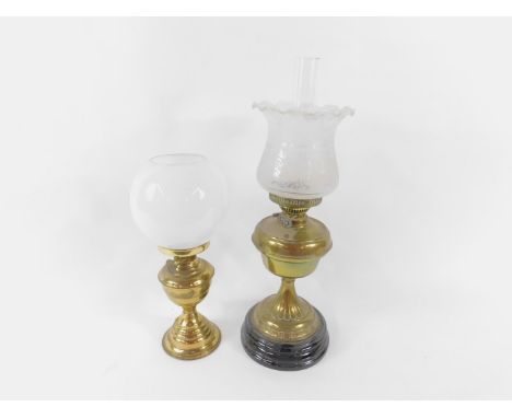 A brass duplex early 20thC oil lamp, raised on a black pottery circular socle, with chimney and etched and frosted frill glas