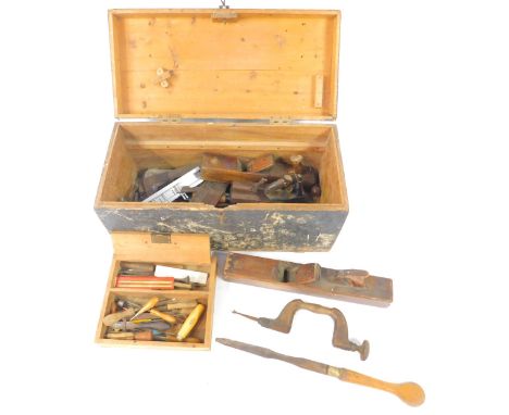 A carpenter's tool chest containing planes, braces, chisels, and sundry further tools, vintage and modern.