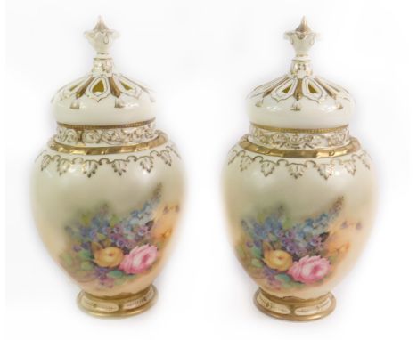 A pair of Royal Worcester style porcelain pot pourri vases and covers, decorated with roses and other flowers against a blush
