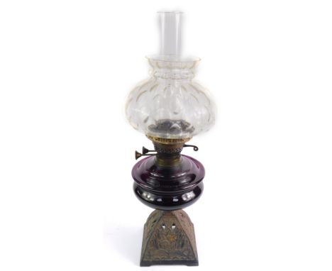 A Victorian cast iron oil lamp, with an amethyst glass reservoir, with chimney and a clear honeycomb glass shade, 55cm high.