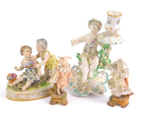 A late 18thC Derby porcelain chamber stick base modelled as a putto, seated on a bough with flowers, on a rococo scroll base,