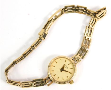 A Rotary lady's 9ct gold circular cased wristwatch, champagne dial bearing gold batons, on a 9ct gold three bar gate bracelet