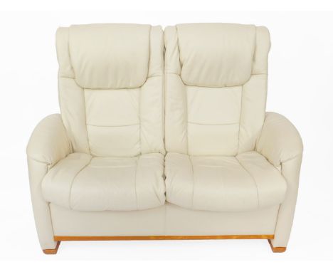 A cream leather two seater recliner Stressless sofa, 138cm W, 60cm D.