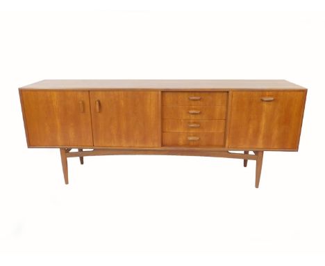 A 1960's G-Plan teak sideboard, with four short drawers flanked by two cupboard doors opening to reveal a single shelf, and a