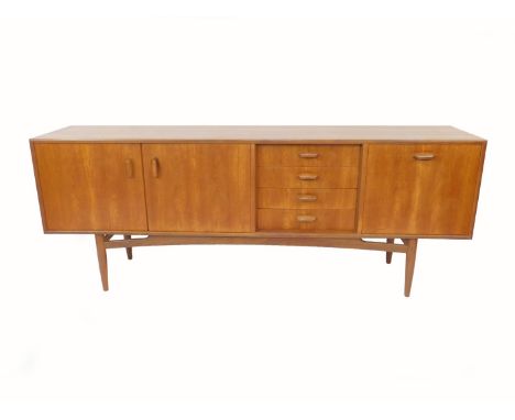 A 1960's G-Plan teak sideboard, with four short drawers flanked by two cupboard doors opening to reveal a single shelf, and a