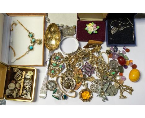 A collection of costume jewellery to include silver buckle bangle, Victorian silver mourning brooch, an amber type bead measu